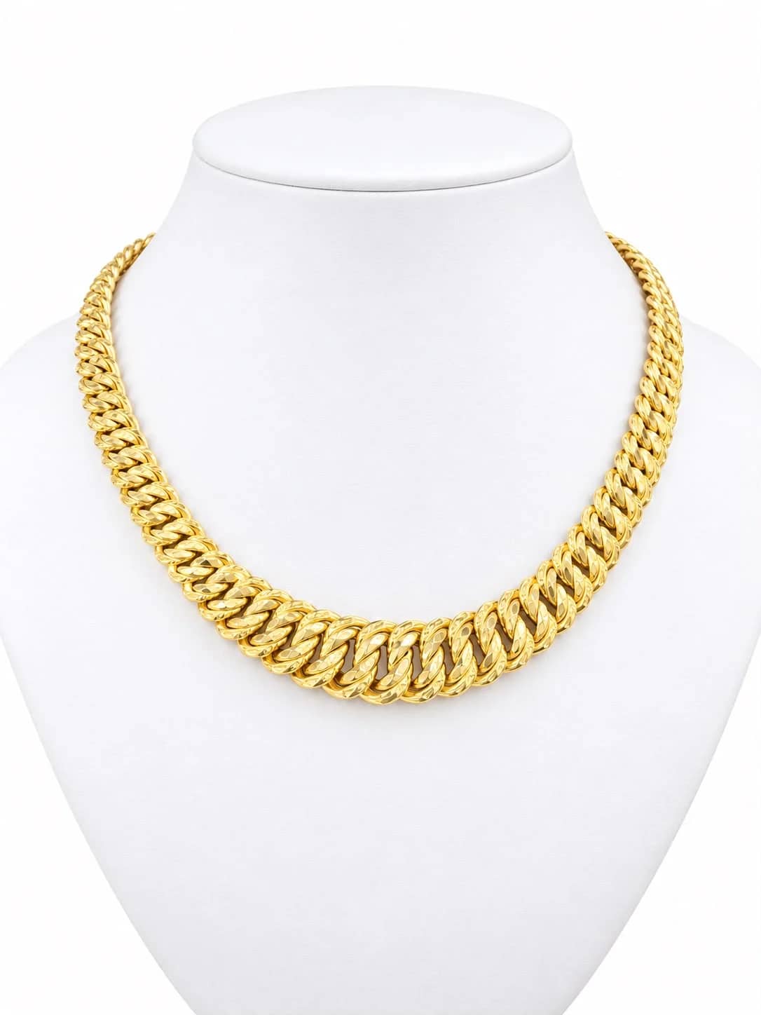 Graduated diamond-cut gold Cuban necklace on a white bust